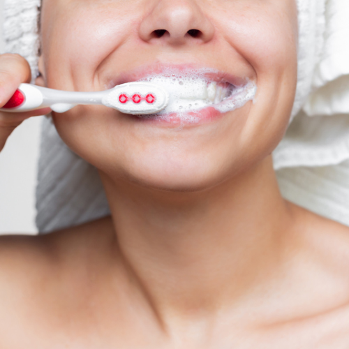 Persona cepillando sus dientes con pasta dental