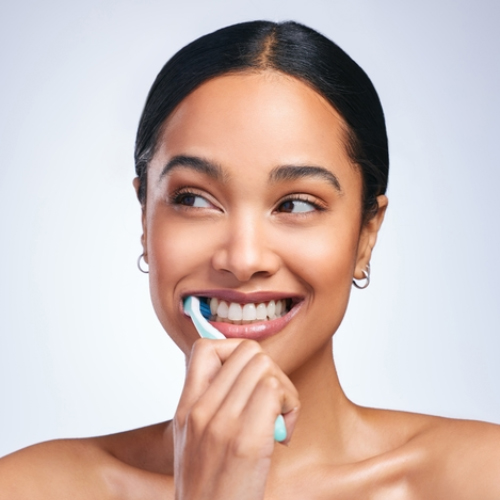 Mujer cepillándose los dientes correctamente