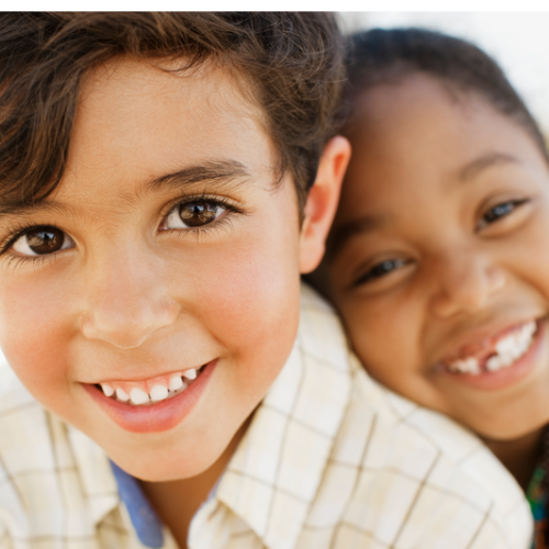 Dos niños felices sonriendo a la cámara