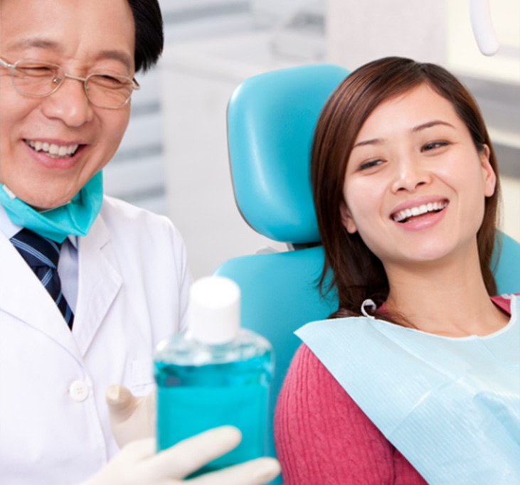 Dentista mostrando enjuague bucal a paciente antes del procedimiento