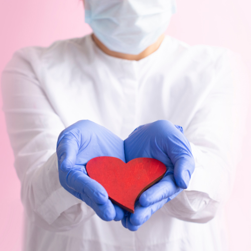 Profesional de la salud sosteniendo un corazón rojo