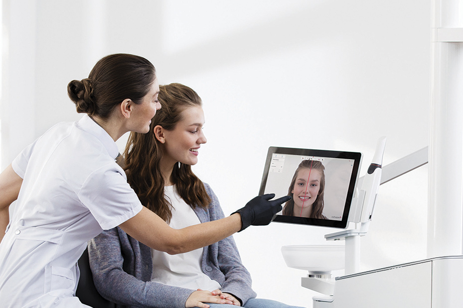 Odontóloga muestra escaneado dental 3D a paciente joven en consultorio moderno con tecnología avanzada