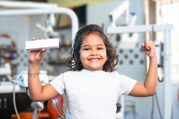niña sonriendo y sosteniendo caja en la mano