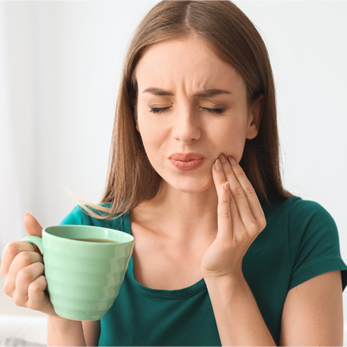 mujer con dolor en los dientes